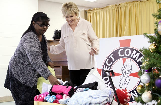 Rachel Rodemann Times Record Abbie Taylor Cox, executive director of Project Compassion Inc., right, thanks Patricia Hardy, Tuesday, Dec. 3, 2013, as Hardy donates socks and other comfortable clothes for the Project Compassion Hearts of Gold fundraiser and open house at the St. Scholastica Retreat Center in Fort Smith.