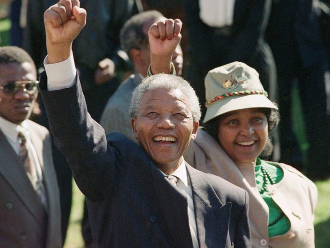 FILE - In this July 7, 1991, file photo, newly-elected African National Congress President Nelson Mandela and his wife, Winnie, greet the crowd after arriving at a rally and a week-long national ANC conference held inside South Africa for the first time in 30 years.