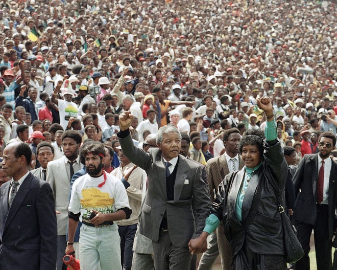 In this Feb. 13, 1990 file photo, Nelson Mandela and Winnie Mandela give black power salutes as they enter Soccer City stadium in the Soweto township of Johannesburg, South Africa, shortly after his release from 27 years in prison. South Africa's president Jacob Zuma said Thursday that Mandela has died. He was 95.