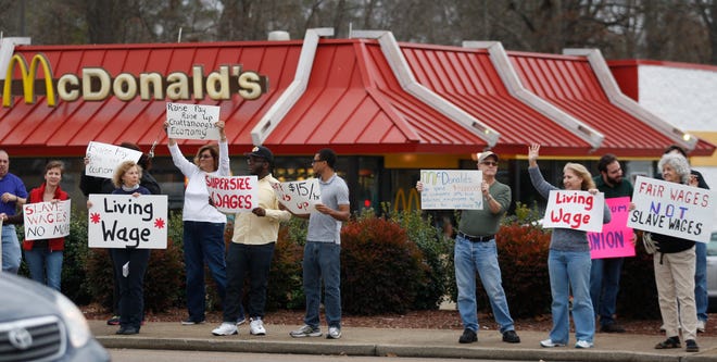 Protesters hold signs during a demonstration Thursday on a sidewalk near the McDonald's in Chattanooga, Tenn. Demonstrators were taking part in a larger national campaign protesting low wages.