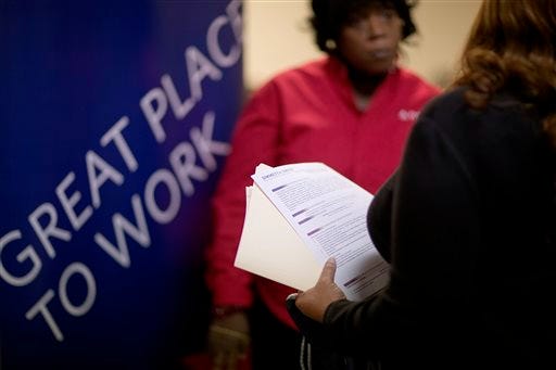 FILE - In this Thursday, Nov. 14, 2013, file photo, Jimmetta Smith, of Lithonia, Ga., right, the wife of a U.S. Marine veteran, holds her resume while talking with Rhonda Knight, a senior recruiter for Delta airlines, at a job fair for veterans and family members at the VFW Post 2681, in Marietta, Ga. The Labor Department issues the November jobs report on Friday, Dec. 6, 2013. (AP Photo/David Goldman, File)