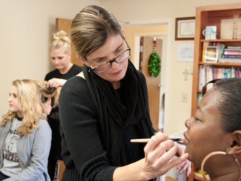 Makeup artists Katie Norrell, back, and Renee Armor prepare two Help-Portrait clients for their photo session on Saturday. Norrell and Armor volunteered their time for the event at Catholic Charities of Northwest Florida.