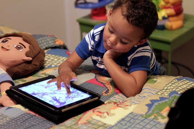 In this Friday, Oct. 21, 2011 photo, Frankie Thevenot, 3, plays with an iPad in his bedroom at his home in Metairie, La. About 40 percent of 2- to 4-year-olds (and 10 percent of kids younger than that) have used a smartphone, tablet or video iPod, according to a new study by the nonprofit group Common Sense Media.  (AP Photo/Gerald Herbert)