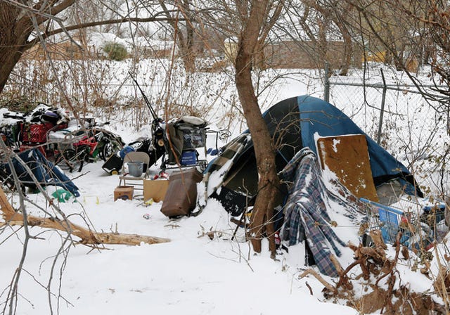 This photos shows a homeless encampment near a neighborhood following a winter storm in Oklahoma City, Friday, Dec. 6, 2013. Despite the recent winter storm, some of the homeless do not want to leave their tent to go to a shelter. AP Photo/Sue Ogrocki 
 Oklahoma City police Sgt. Bartels, who did not want to give his first name, waits for the occupants at a homeless encampment to come out of their tent in Oklahoma City, Friday, Dec. 6, 2013. William Martz is at the door of the tent. Two Oklahoma City police officers who said they had received complaints about the encampment, came to check on the occupants. AP Photo/Sue Ogrocki