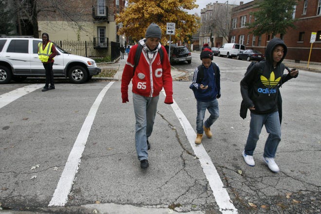 Eighth-grader Devion Allen, left, walks home with friends from Chopin Elementary School in Chicago. Martha Irvine/The Associated Press