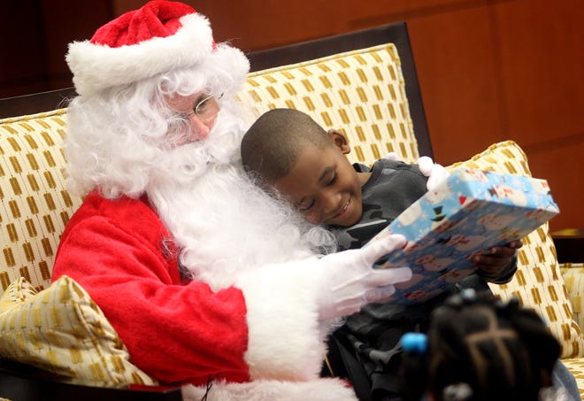 In this Star File photo Graham Elementary School second grader Jonathan Ussery hugs Santa while receiving a gift at the Shelby Rotary Christmas party at the LeGrand Center. Brittany Randolph/The Star