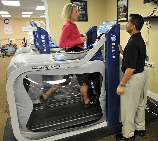 Steve Bisson/Savannah Morning News Leah Sparks uses the Alter G anti-gravity treadmill while Ernest Ledesma looks on.