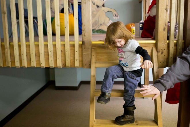 Izabella Haefling, 3, is helped down a ladder by her mom, Suzette Haefling, Tuesday at a ribbon-cutting ceremony for Tree Top Innovative Learning Center. The Haeflings met Tree Top owners Tiffany and Chris Campbell when they enrolled Izabella in the Campbells’ previous child care center.