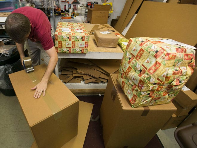 Walter Arnold, manager of the PakMail at Churchill Square in Ocala, FL, packs Christmas presents for customers to be shipped, Thursday afternoon, December 5, 2013. As people make more internet purchases and send more gift cards, fewer people are making trips to local package/shipping stores.