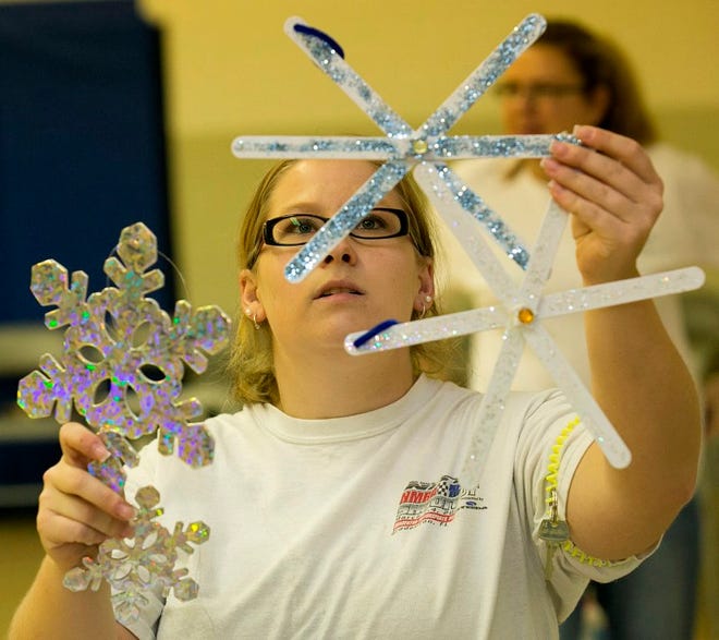 Megan Shipe, chair of the Hillcrest School parade float, checks on snowflakes made by students that will be on display as part of the decoration of this year's float.