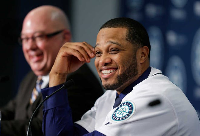 Robinson Cano, right, smiles as he sits next to Seattle Mariners general manager Jack Zduriencik, left, after Cano was introduced as the newest member of the Seattle Mariners baseball team, Thursday, Dec. 12, 2013, in Seattle. (AP Photo/Ted S. Warren)