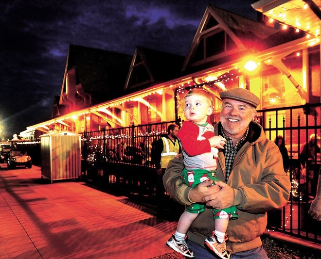 Jeff Inman, of Canton, carries grandson Carter Inman, 2, to their seats on the Polar Express on Friday at the Dennison Depot. Carter's great-grandmother and Inman's mother-in-law, Maxine Lukens, served at the Dennison Depot Canteen during World War II.