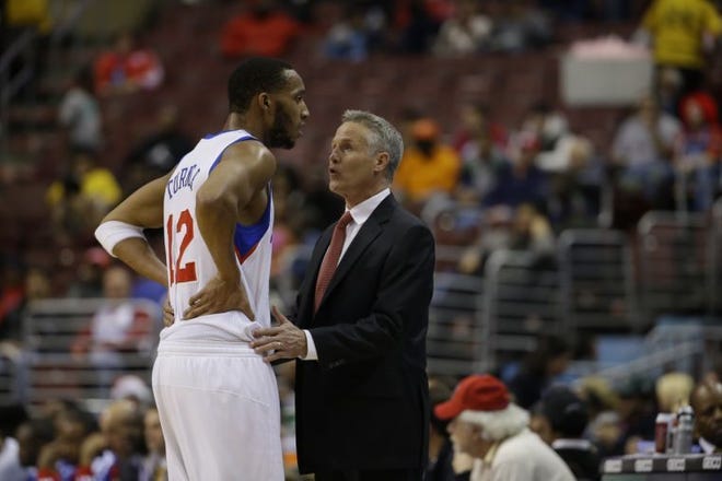 The Sixers' Evan Turner and coach Brett Brown talk during Monday's loss to the Clippers.