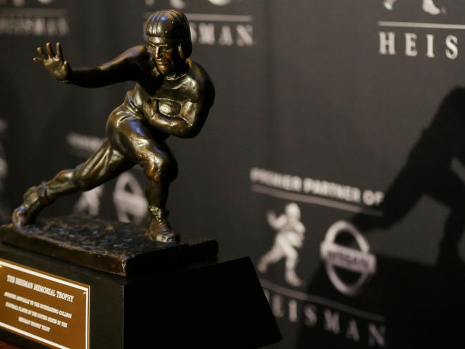 The shadow of the 2013 Heisman Trophy is seen on a backdrop during an informal media availability with the finalists, Friday, Dec. 13, 2013, in New York.