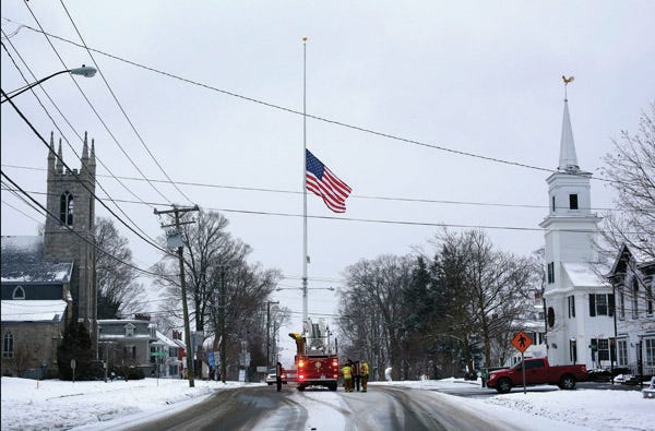 On the first anniversary of the Sandy Hook massacre, firefighters lower the town’s flag on Main Street to half-staff in honor of the victims, on Saturday in Newtown, Conn. AP Photo/Robert F. Bukaty