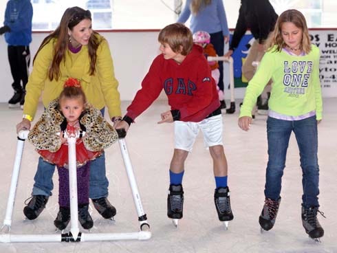 Cassidy Lyons Pickens, left, helps her daughter, Presley, as they skate with Adam Armbruster, center, and his sister Leah Armbruster on Sunday at the Baytowne on Ice skating rink at Sandestin.