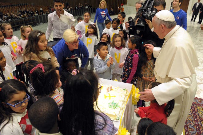 In this picture provided by the Vatican newspaper L'Osservatore Romano, Pope Francis is presented with a birthday cake, at the Vatican, Saturday, Dec. 14, 2013. Pope Francis has received a candle-topped birthday cake three days early, a surprise from children at the Vatican. The pontiff turns 77 on Dec. 17. A group of children on Saturday presented him with the treat after he visited a Vatican dispensary which provides pediatric care. Francis blew out the candles. Thanking the youngsters for the cake, he promised: "I'll tell you later if it's good or not." The dispensary on the Vatican grounds has been distributing for more than 90 years milk, clothing, diapers, toys and even baby carriages to families in need. The dispensary on the Vatican grounds has been distributing for more than 90 years milk, clothing, diapers, toys and even baby carriages to families in need. (AP Photo/L'Osservatore Romano)