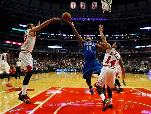 Orlando Magic point guard Jameer Nelson, center, shoots between Chicago Bulls center Joakim Noah, left, and point guard D.J. Augustin, right, during the second half of an NBA basketball game in Chicago on Monday, Dec. 16, 2013. The Magic won 83-82. (AP Photo/Jeff Haynes)