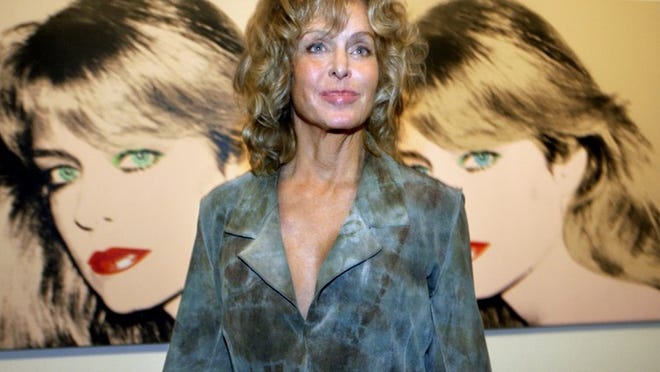 Farrah Fawcett poses with the two Andy Warhol portraits of her at an event at the Andy Warhol Museum in 2003.