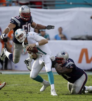 AP photo

New England defensive tackle Sealver Siliga (71) and defensive end Rob Ninkovich (50) come down on Miami Dolphins quarterback Ryan Tannehill (17) for a sack during NFL action Sunday.