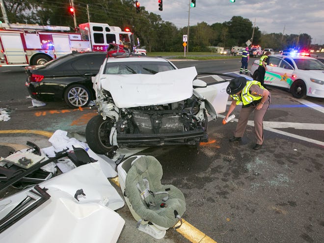 In this Dec. 6, 2013 file photo, Florida Highway Patrol troopers work at the accident scene after three cars collided at Southeast 31st Street and Maricamp Road in Ocala.