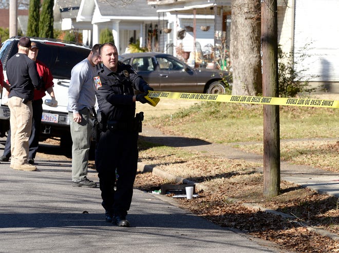 Police secure a crime scene after a man was either cut or stabbed, Tuesday, Dec. 17, 2013, on Alabama Avenue in Gadsden, Ala.