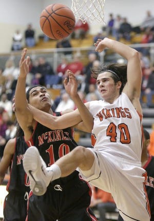 McKinley High School’s Sam Burton (left) Hoover’s Tony Iero go after a loose ball during the third quarter of Tuesday’s game. The Vikings handed the Bulldogs their first Federal League loss.