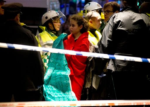 A girl wraps herself in a blanket provided by rescue services following an incident during a performance at the Apollo Theatre, in London's Shaftesbury Avenue, on Thursday evening.