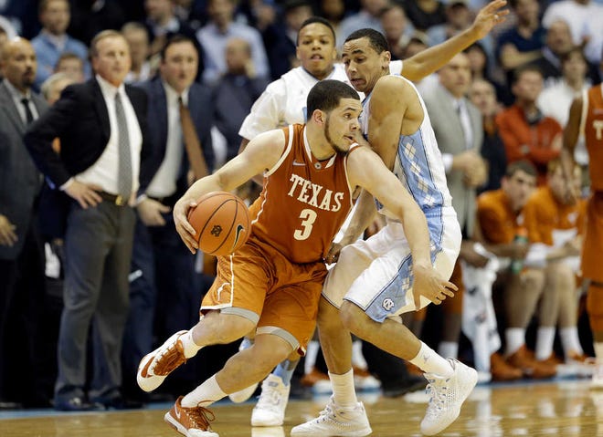 Texas' Javan Felix (3) is guarded by North Carolina's Marcus Paige during the second half of an NCAA college basketball game in Chapel Hill, N.C., Wednesday, Dec. 18, 2013. Texas won 86-83. (AP Photo/Gerry Broome)