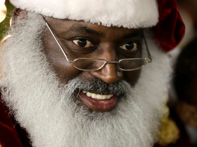 Dee Sinclair, portraying Santa Claus, reads a story to children in Atlanta. "Kids don't see color. They see a fat guy in a red suit giving toys," says Sinclair, 50.