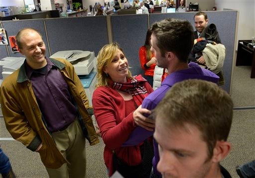 Kerri Anderson, center, grabs Seth Anderson, no relation, to congratulate him after his marriage to Michael Ferguson, foreground, Friday, Dec. 20, 2013, in Salt Lake City. At left is Jeff Anderson, Kerri's husband. Michael Ferguson and Seth Anderson were the first couple to be married under the now legal same-sex marriage decision handed down by a federal judge just minutes before their ceremony at the county offices.