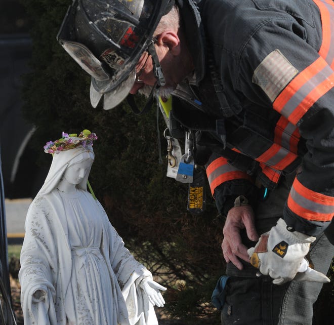HYANNIS-- 12/20/13-- Hyannis Fire Department Lt. Tom Kenney searches the area in back of the St. Francis Xavier rectory for hand parts to a concrete statue of the Virgin Mary after it was struck and trapped behind a car which crashed into the back of the building on Friday morning