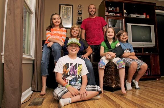 Ethan Martin, 12, front, spends time with his family in this Star file photo from September 2012. Family members, from left, include Heather, 8, mother Nicole, father Brad, Hannah, 7, and Connor, 10, at their Shelby home. (Star file photo)
