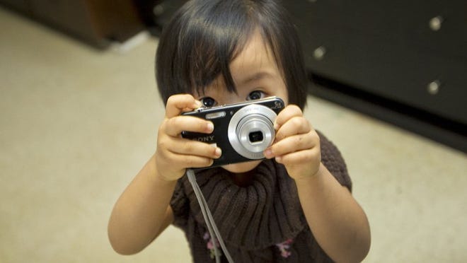 Daughter Okee is very playful yet shy. She turns a small, inexpensive camera into a toy.