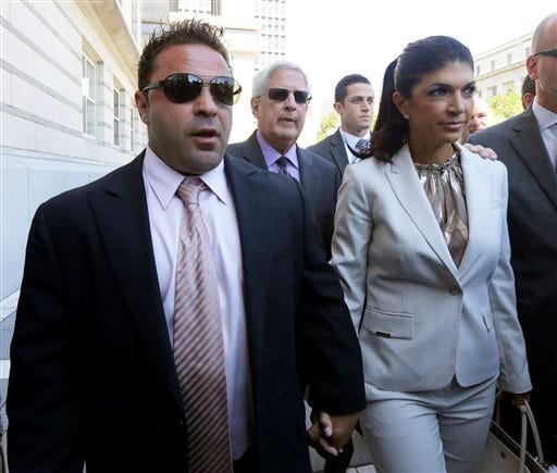 FILE - In this July 30, 2013 file photo, "The Real Housewives of New Jersey" stars Giuseppe "Joe" Giudice, 43, left, and his wife, Teresa Giudice, 41, of Montville Township, N.J., walk out of Martin Luther King, Jr. Courthouse after an appearance in Newark, N.J. Federal prosecutors cited the Giudice's "Real Housewives" income in court filings and accuse the couple of hiding assets in a bankruptcy case filed after the show's first season. Both have pleaded not guilty to a host of financial fraud charges dating back to 2001. (AP Photo/Julio Cortez, File)