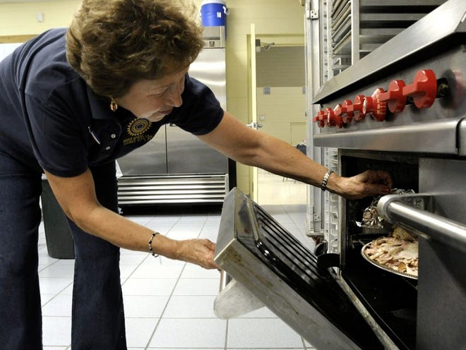 Joy Sims checks on the turkey in the oven.