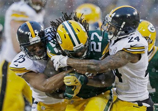 Pittsburgh Steelers' Ryan Clark (25) and Ike Taylor (24) try to stop Green Bay Packers' Eddie Lacy during the first half of an NFL football game Sunday, Dec. 22, 2013, in Green Bay, Wis. (AP Photo/Jeffrey Phelps)