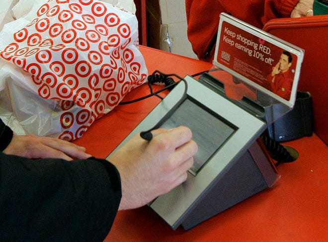 FILE - In this Jan. 18, 2008 file photo, a customer signs his credit card receipt at a Target store in Tallahassee, Fla. The U.S. is the juiciest target for hackers hunting credit card information. And experts say incidents like the recent data theft at Target's stores will get worse before they get better. That's in part because U.S. credit and debit cards rely on an easy-to-copy magnetic strip on the back of the card, which stores account information using the same technology as cassette tapes. The breach that exposed the credit card and debit card information of as many as 40 million Target customers who swiped their cards between Nov. 27 and Dec. 15 is still under investigation. (AP Photo/Phil Coale, File)