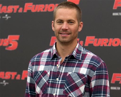 FILE - In this April 29, 2011 file photo, actor Paul Walker poses during the photo call of the movie "Fast and Furious 5," in Rome. Universal Pictures has shut down production on "Fast & Furious 7" indefinitely following the death of its star, Walker. The studio announced Wednesday, Dec. 4, 2013, that the film will shut down "for a period of time so we can assess all options available to move forward with the franchise." (AP Photo/Andrew Medichini, File)
