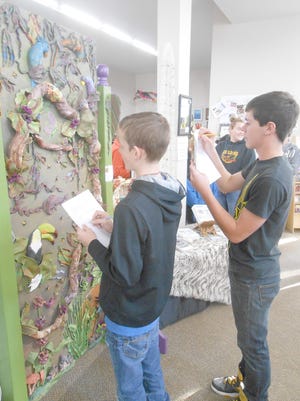 Sophomores Bryon Semmler and Skylar Smith critique a large clay sculpture in the gallery.