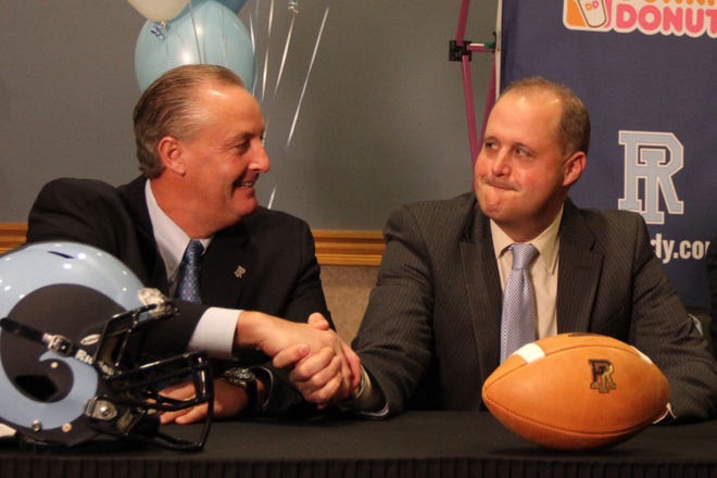 Jim Fleming, left, is introduced as the new football coach at URI in a news conference Monday. Greeting him is Thorr Bjorn, the school’s A.D.