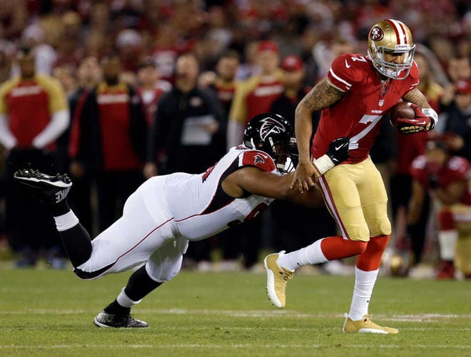 San Francisco 49ers quarterback Colin Kaepernick (7) is slowed by Atlanta Falcons defensive tackle Corey Peters during the first half of an NFL football game in San Francisco, Monday, Dec. 23, 2013. (AP Photo/Tony Avelar)