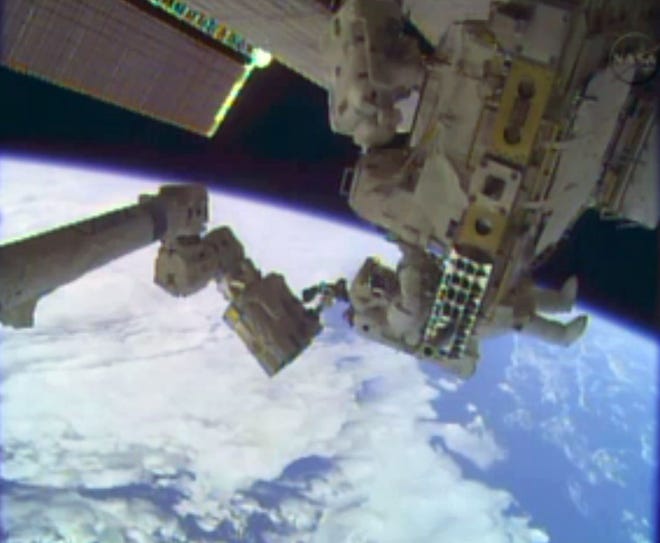 In this image taken from video provided by NASA, astronauts Rick Mastracchio, top, and Michael Hopkins work to repair an external cooling line on the International Space Station on Monday, Dec. 24, 2013, 260 miles above Earth. The external cooling line -- one of two -- shut down Dec. 11. The six-man crew had to turn off all nonessential equipment, including experiments.