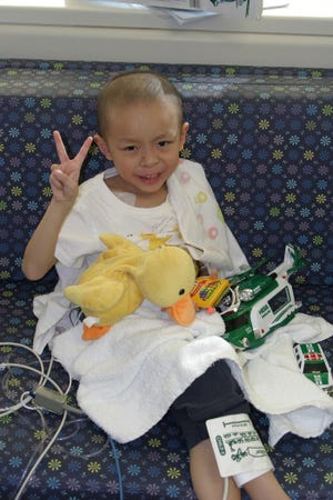 Provided by Eileen Kay Colin Lam, at his Hong Kong home, shows his love for miniature cars. The 6-year-old had surgery to remove an adrenal gland tumor in June.
