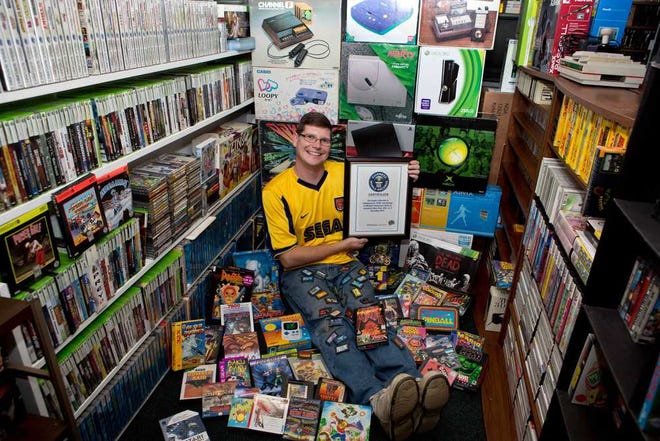 Michael Thomasson poses in the basement of his suburban Buffalo home, where he stores his collection of video games. Thomasson is featured in the just-released "Guinness World Records 2014 Gamer's Edition" for having the largest collection of video games, 10,607.