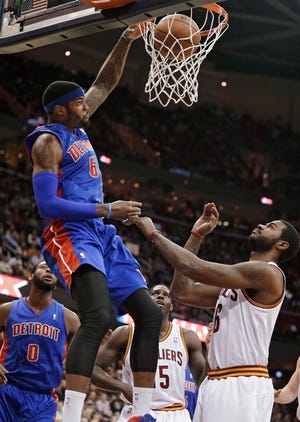 The Pistons’ Josh Smith dunks in front of the Cavaliers’ Earl Clark (right) during the first quarter Monday in Cleveland. Smith scored 25 points in the victory.