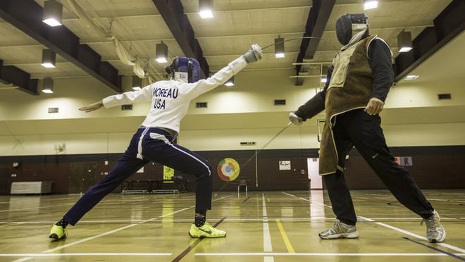 Monet Moreau 17, left, practices her fencing techniques with her father John at Texas State University. She is on track to go to international competition in China this summer.