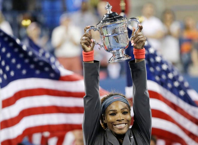 In this Sept. 8, 2013, file photo, Serena Williams, of the United States, holds up the championship trophy after defeating Victoria Azarenka, of Belarus, during the women's singles final of the U.S. Open tennis tournament in New York. Williams is The Associated Press' 2013 Female Athlete of the Year, easily winning a vote by news organizations.