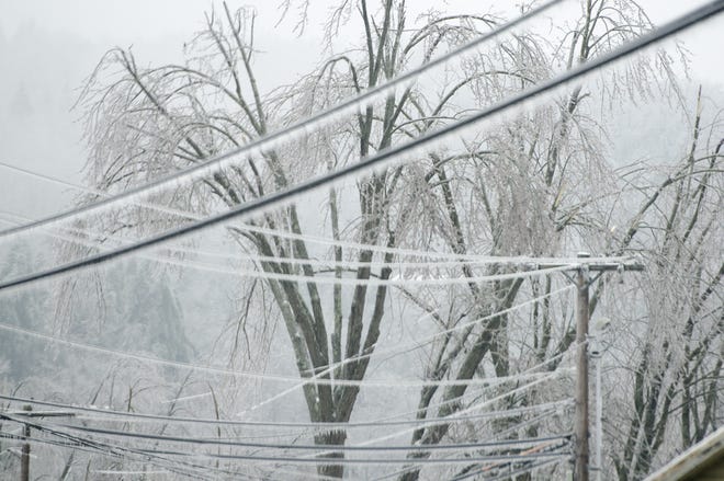 Trees and power lines grow heavy with ice as freezing rain continues into Monday morning, Dec. 23, 2013, in Cambridge, Vt. From Michigan to Maine, hundreds of thousands remain without power days after a massive ice storm _ which one utility called the largest Christmas-week storm in its history _ blacked out homes and businesses in the Great Lakes and Northeast. (AP Photo/Burlington Free Press, Emily McManamy)