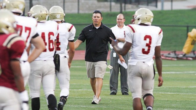 Rouse football coach Joshua Mann, center, led the Raiders to the fourth round of the Class 4A, Division I playoffs in 2013. Rouse, a fourth-year varsity football program, has won 20 games over the past two seasons. CREDIT: Chad Taylor/For American-Statesman